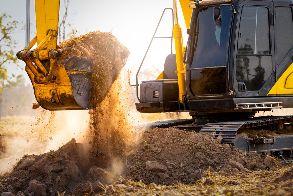 close up of excavator at construction site. backhoe digging soil for earthwork and construction business. excavating machine at work. heavy machinery for earth moving and construction site development